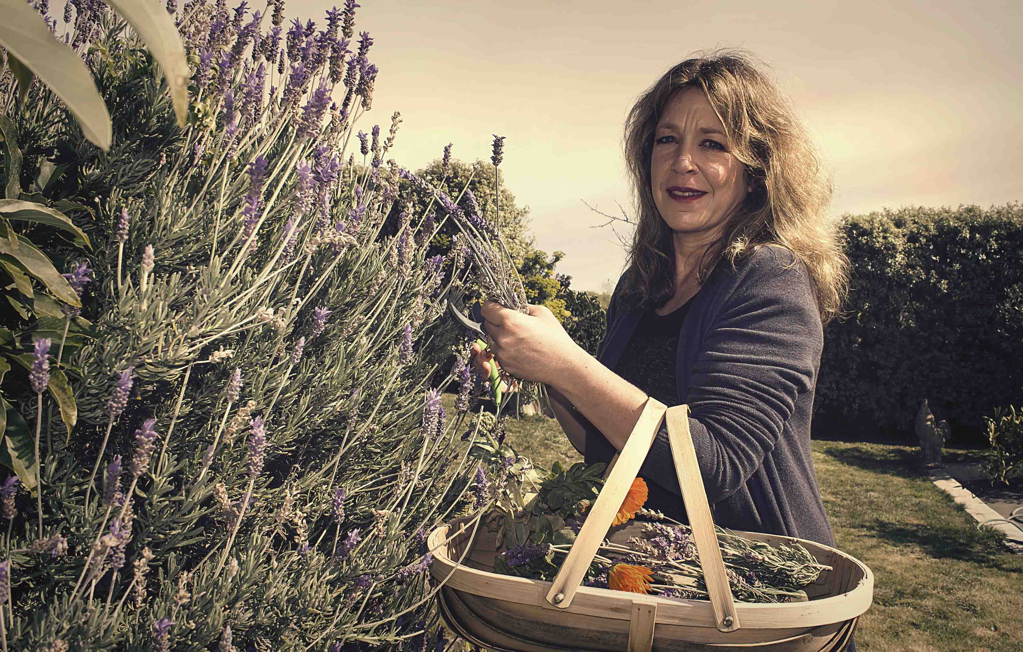 Georgina gathering medicinal herbs in garden